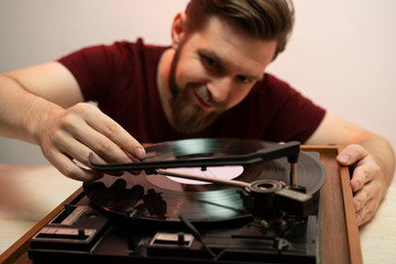 Vinyl lover, man playing record on vintage gramophone 