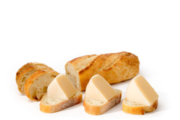crusty French stick bread cut into slices topped with smoked Gouda cheese wedges isolated on white