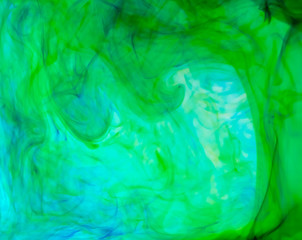 Blurred photo of food color drop and dissolve in water for background and texture concept.