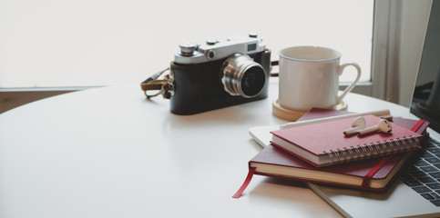 Cropped shot minimal workplace with notebook and vintage camera