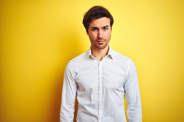 Young handsome businessman wearing elegant shirt standing over isolated yellow background skeptic and nervous, frowning upset because of problem. Negative person.