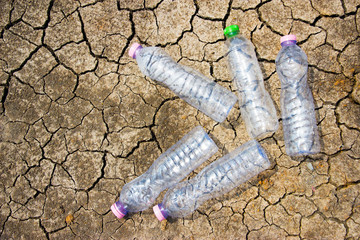 many plastic bottles on cracked ground with copy space.recycled and reduce global warming concept