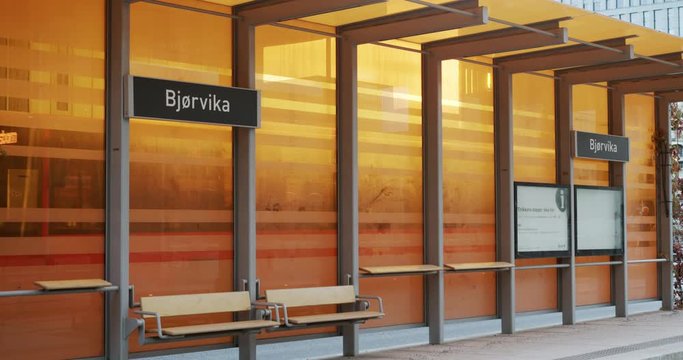 Cinema 4K medium gimbal shot with parallax motion of new orange bus and tram station in the new Bj&oslash;rvika Opera district project, in Oslo Norway.
