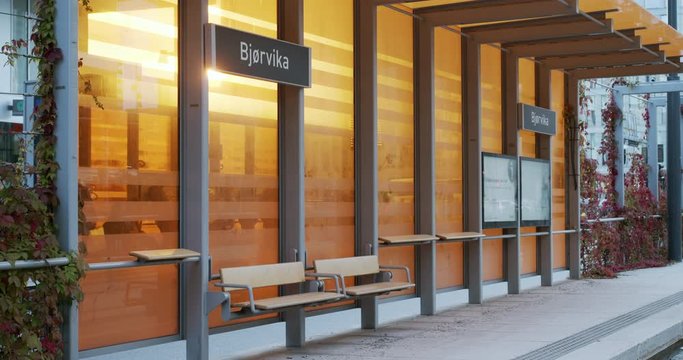 Cinema 4K medium gimbal shot with parallax motion of new orange bus, train and tram station in the new Bj&oslash;rvika Opera quarter project, in Oslo Norway.