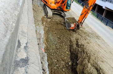 xcavator digging a ditch on the construction site.