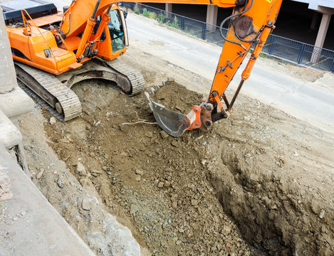 xcavator digging a ditch on the construction site.