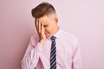 Young handsome businessman wearing shirt and tie standing over isolated pink background with sad expression covering face with hands while crying. Depression concept.