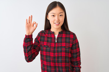 Young chinese woman wearing casual jacket standing over isolated white background smiling positive doing ok sign with hand and fingers. Successful expression.