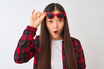 Young chinese woman wearing casual jacket and sunglasses over isolated white background scared in shock with a surprise face, afraid and excited with fear expression