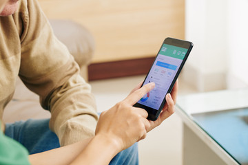 Hands of medical nurse showing senior man how to use mobile health monitoring application on smartphone