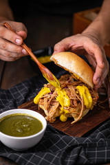 Closeup of chef hands preparing hamburger  food.  American chef making hamburger  at restaurant.  Chef serving traditional american burger served on a cuting board in lighting studio