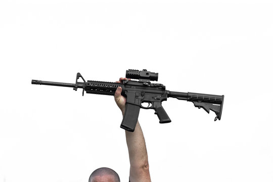 Man Holding AR-15 or AR-16 Automatic Assault Rifle In Air Above His Head