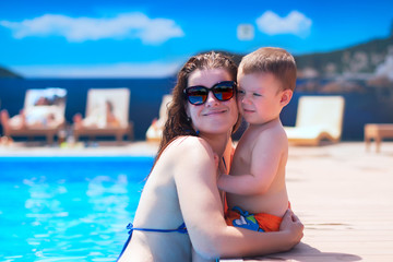 Close-up of mother and son by the pool during summer vacation People sunbathing relax family day off