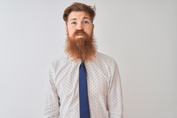 Young redhead irish businessman standing over isolated white background puffing cheeks with funny face. Mouth inflated with air, crazy expression.