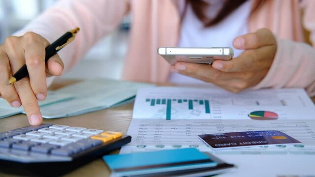 Stressed young woman make payment online with credit card, checking bills and calculating expenses in the living room at home
