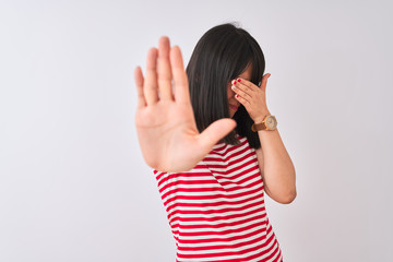 Young beautiful chinese woman wearing red striped t-shirt over isolated white background covering eyes with hands and doing stop gesture with sad and fear expression. Embarrassed and negative concept.