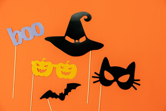 Table top view aerial image of decorations Happy Halloween day background holiday concept.Flat lay objects to party pumpkins photo booth prop and spider & bat hat witch on orange  paper wallpaper.