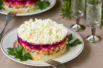 Layered vegetable salad with salted herring and eggs    
