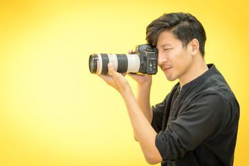 Fototapeta premium Young Professional photographer with camera in on photo studio background.