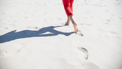 woman walking on the beach white sand barefoot footprint