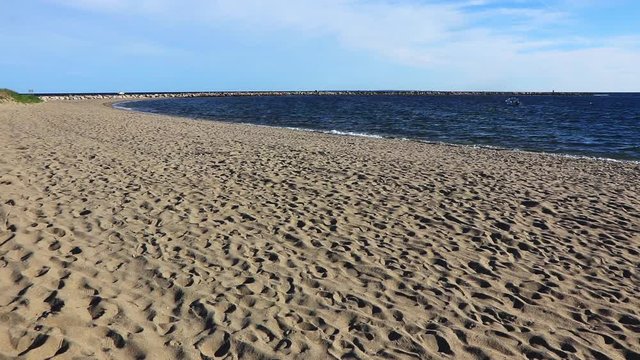 Slow motion gimbal shot of beach and ocean at Point Judith Harbor Refuge