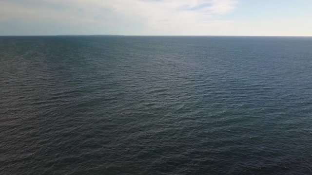 Aerial calm empty vast ocean with rolling swell to horizon with copy space