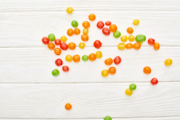 top view of colorful bonbons on white wooden table, Halloween treat