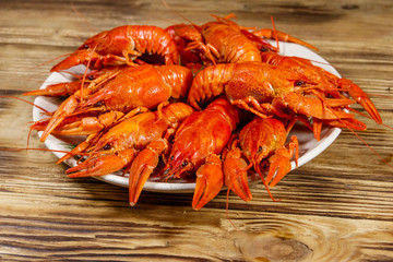 Boiled crayfish in plate on wooden table