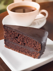 Slice of chocolate cake on a white plate. Chose up of chocolate layer cake.