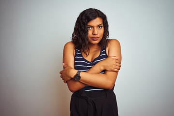 Obraz premium Transsexual transgender woman wearing striped t-shirt over isolated white background shaking and freezing for winter cold with sad and shock expression on face