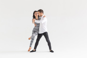 Young couple dancing social latin dance bachata, merengue, salsa. Two elegance pose on white...