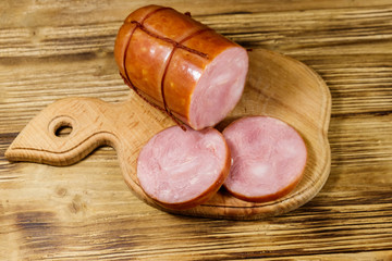 Sliced smoked sausage on cutting board on wooden table
