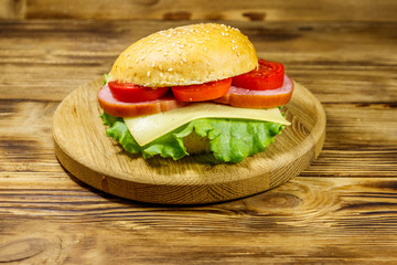 Fresh delicious homemade cheeseburger on wooden table