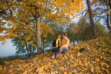 Young couple on lake coast. Sunny Autumn Day.