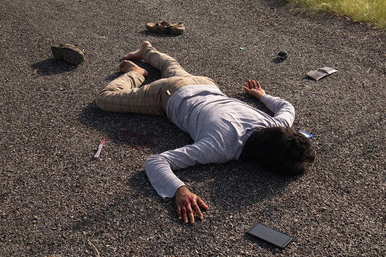 Concept of Crime scene ,High Angle view of victim dead body lying on Roadside.