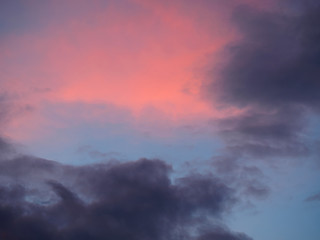 Obraz na płótnie Canvas Dark gray and red clouds on a blue sky background