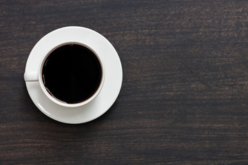 Needle coffee in a white coffee cup Resting on a black wooden table top view