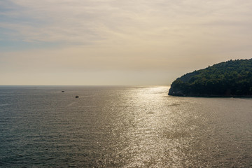 seashore, a hill and ships on the surface