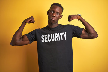 African american safeguard man wearing security uniform over isolated yellow background showing...