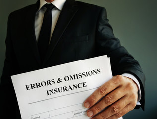 Errors and omissions E&O insurance or professional liability policy in the hands.