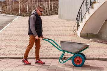A man carries a garden wheelbarrow