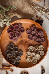 Assortment of sweets without sugar and gluten on a wooden dish. Dessert made from healthy natural ingredients. Beautiful composition of healthy diet candies and flowers