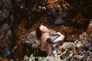 young attractive woman sitting on a rock