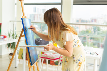 painting art classes. drawing courses. skills imagination and inspiration. Charming student girl creating picture on easel.
