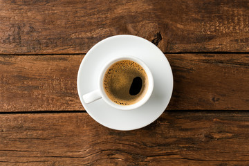 Overhead shot of hot coffee cup on wooden background with copyspace