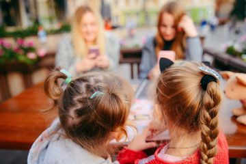 little girl sitting in cafe choosing food from menu