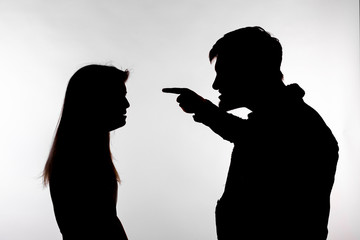 Aggression and abuse concept - man and woman expressing domestic violence in studio silhouette isolated on white background.