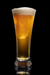 Glass of beer isolated on black background.