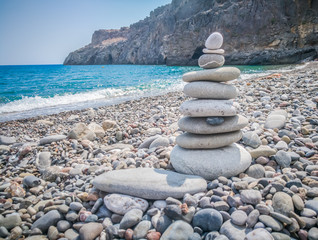 Symbolic scales of stones against the background of the sea and blue sky. Concept of harmony and balance. Pros and cons concept. Copy space for text.