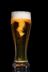 Glass of beer isolated on black background.